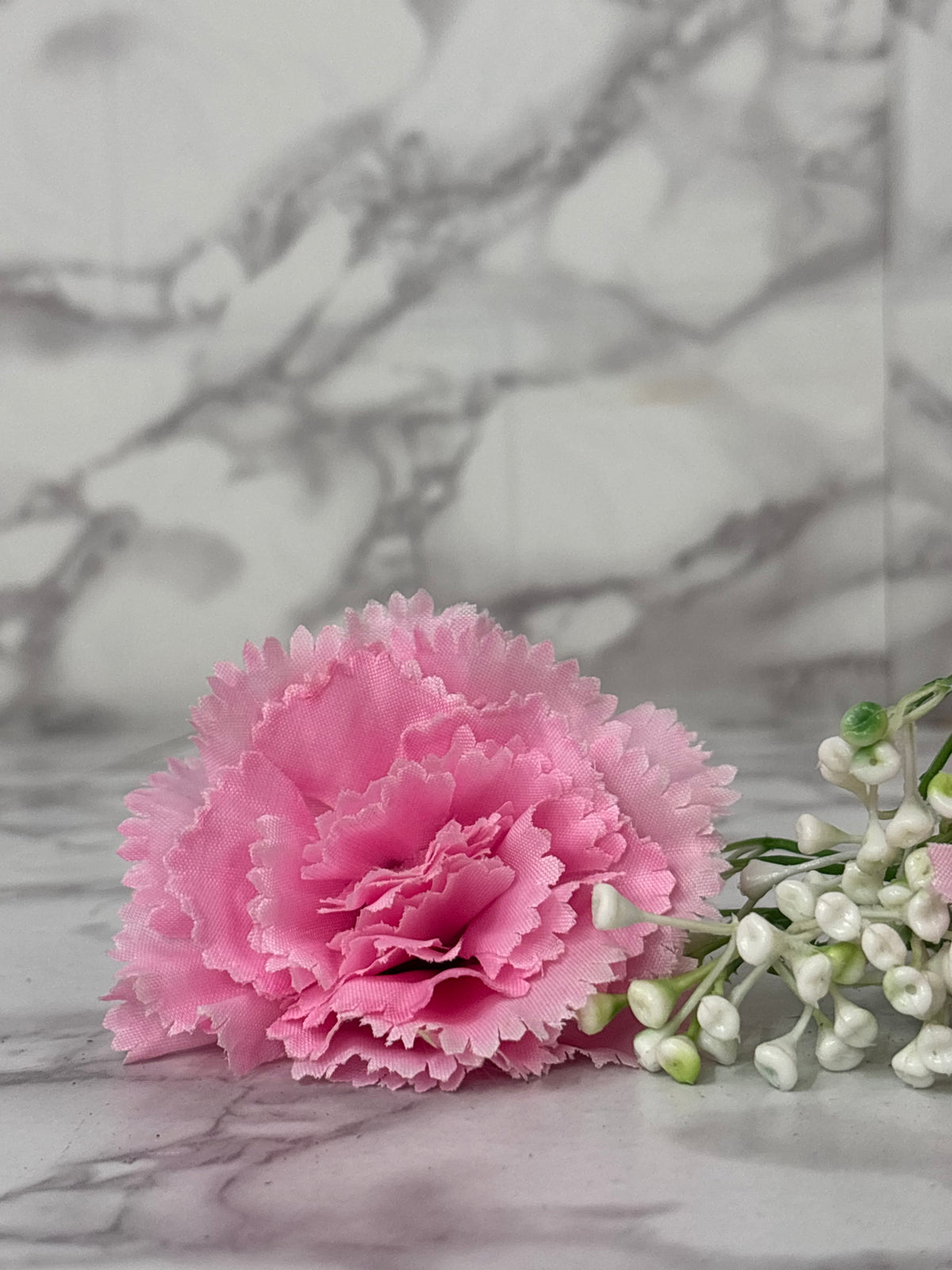 Pink flower and white baby's breath on a marble background